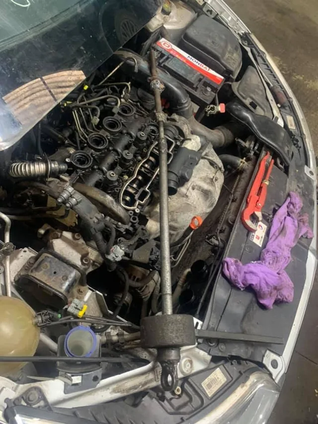 Motor diesel desfăcut, cu extractorul montat pe un injector